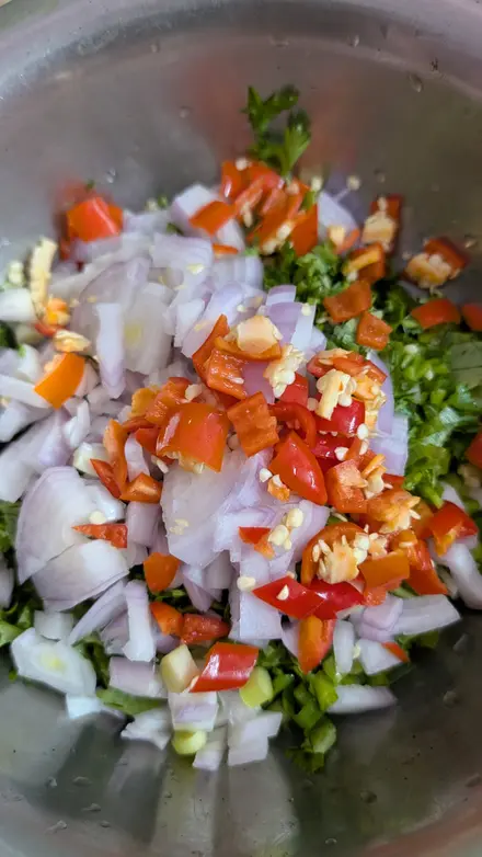 Chopped red onion, red chilli and coriander in a steel bowl